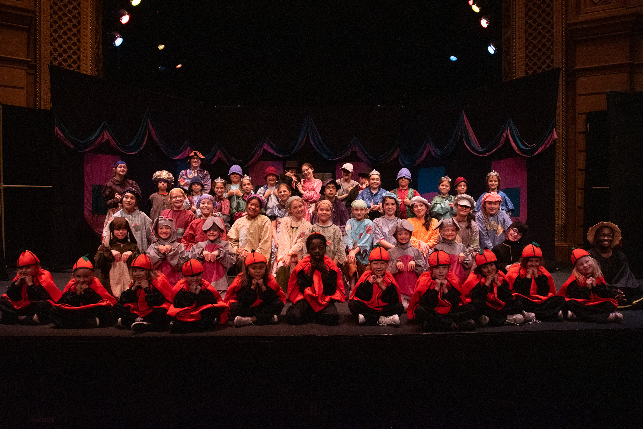 Group of young performers on stage at the end of a performance.